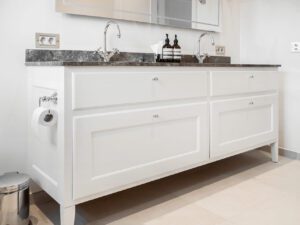 Hvidt snedker badeværelse med grå marmorplade, i Charlottenlund