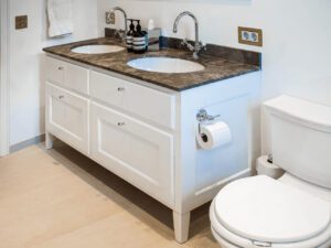 Hvidt snedker badeværelse med marmor bord i Charlottenlund